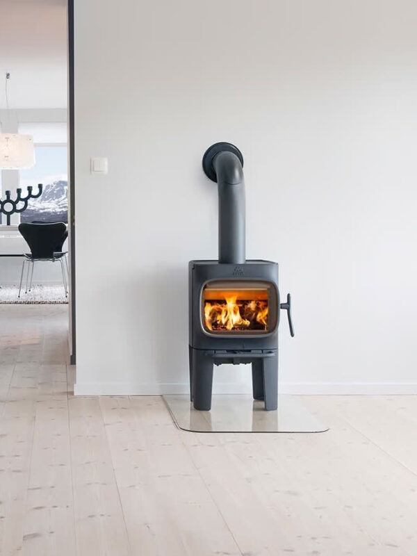 Poêle à bois Jøtul F 105 R LL en fonte, avec porte vitrée, installé dans un salon