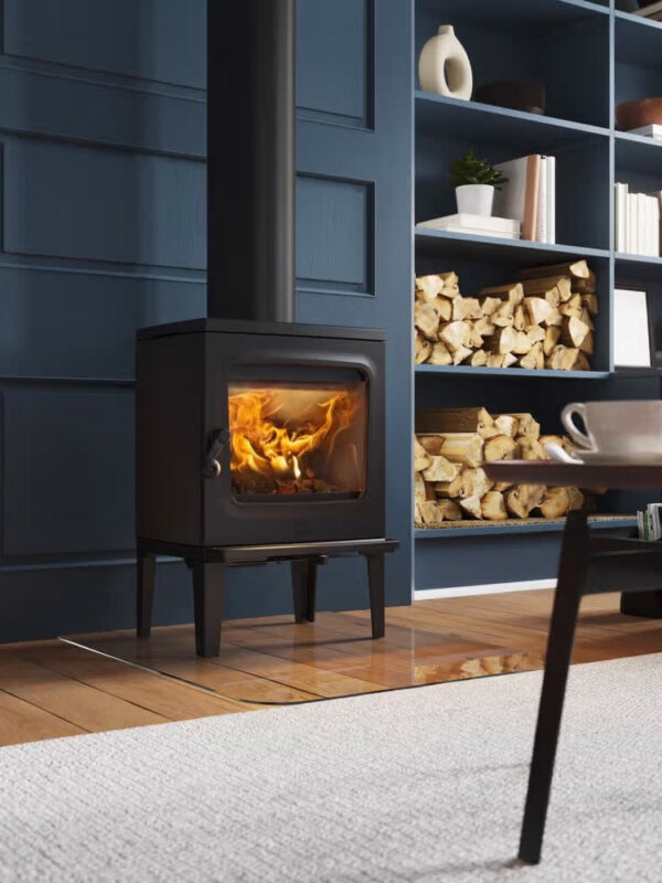 Poêle à bois Jøtul F 205 V2 en fonte, avec porte vitrée, dans un salon bleu nuit