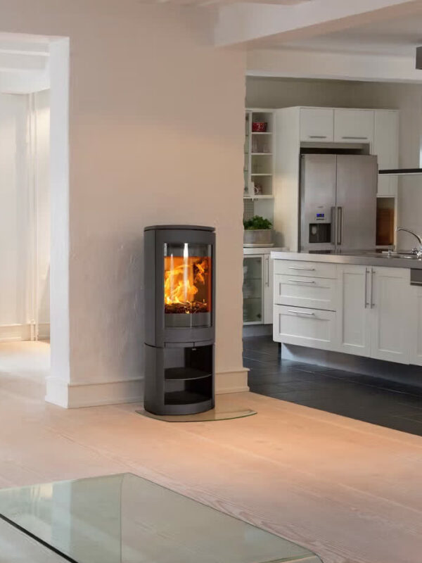Poêle à bois Jøtul F 361 ADVANCE en fonte, avec porte vitrée, dans une cuisine ouverte et lumineuse