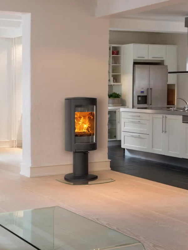 Poêle à bois Jøtul F 363 ADVANCE en fonte, avec porte vitrée, dans une cuisine ouverte et lumineuse