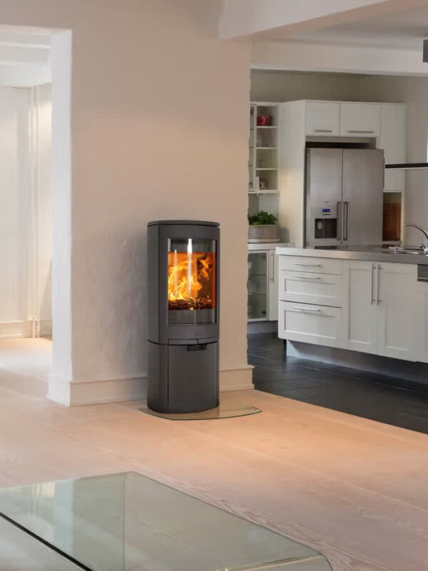 Poêle à bois Jøtul F 368 ADVANCE en fonte, avec porte vitrée, dans une cuisine ouverte et lumineuse