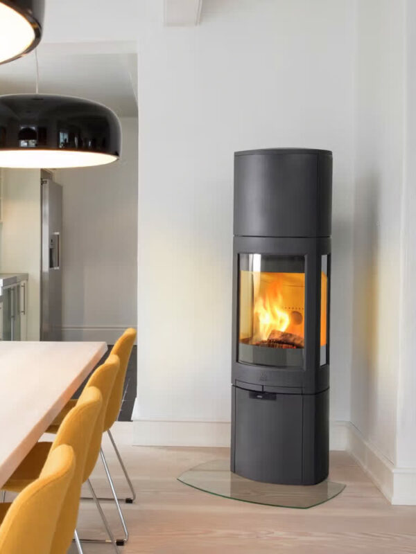 Poêle à bois Jøtul F 378 ADVANCE HIGH TOP en fonte, avec porte vitrée, dans une salle à manger