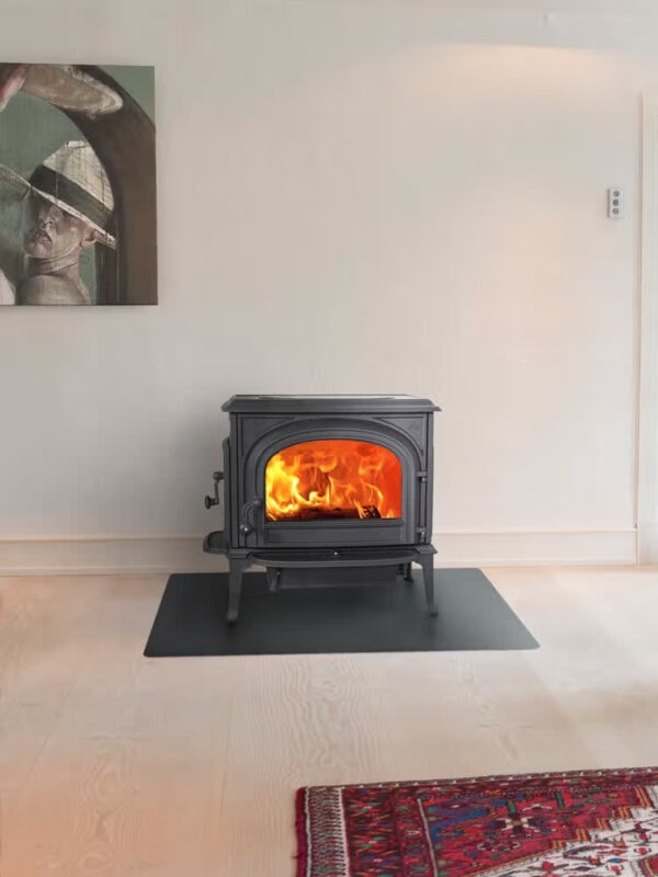 Poêle à bois Jøtul F 500 ECO SE en fonte, avec porte vitrée, dans un intérieur blanc et épuré