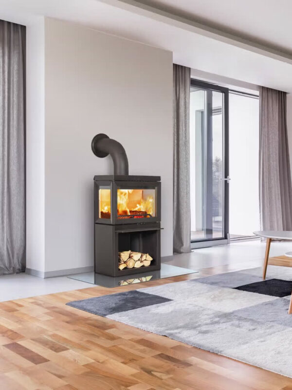 Poêle à bois Jøtul F 520 en fonte, avec porte vitrée, dans un séjour ouvert sur l'extérieur