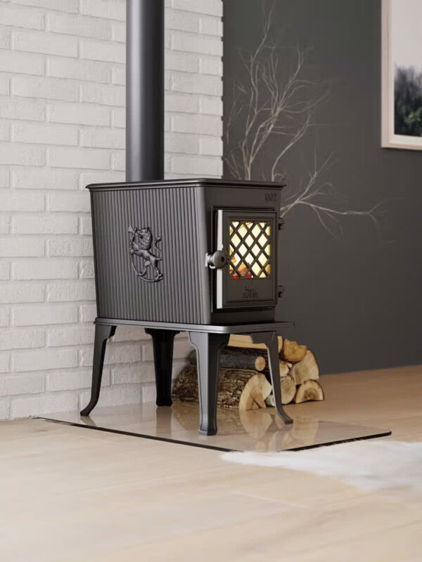 Poêle à bois Jøtul F 602 ECO en fonte, avec porte vitrée, contre un mur en briques blanches