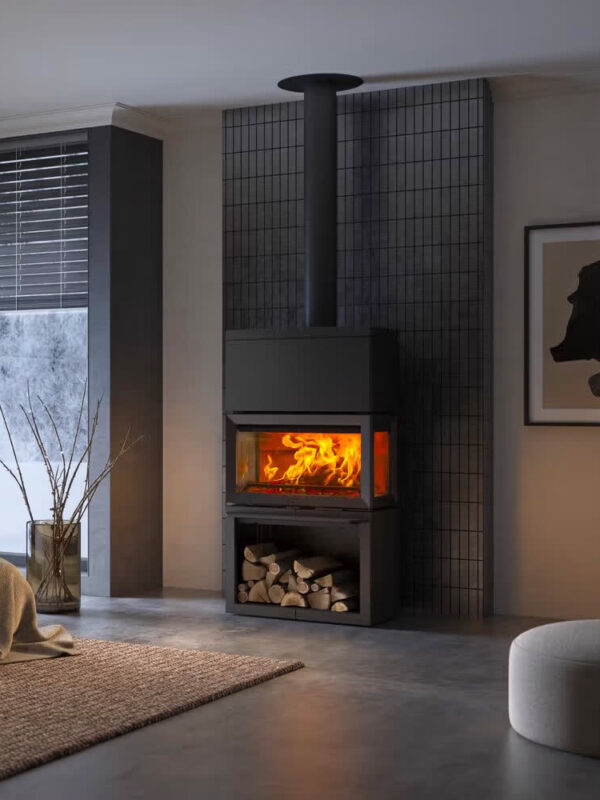 Poêle à bois Jøtul F 620 B HT en fonte, avec porte vitrée, dans un salon gris épuré à la lumière tamisée