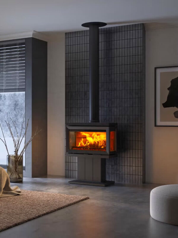 Poêle à bois Jøtul F 620 P en fonte, avec porte vitrée, sur pied central, dans un salon gris épuré